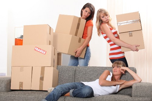 Professional movers carrying furniture during a local removals service